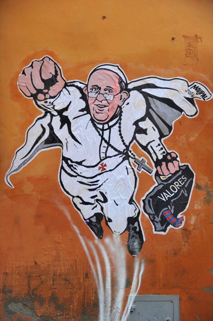 A picture shows a street art mural showing Pope Francis as a superman, flying through the air with his white papal cloak billowing out behind him and holding a bag bearing the word "Values", by Italian street artist Maupal in downtown Rome near the Vatican on January 29, 2014. The image, created by Italian street artist Maupal, was tweeted yesterday by the Vatican communication twitter account ( @PCCS_VA ). Flying forward with his fist raised, the heroic pontiff -- crucifix swinging in the wind -- carries his trademark black bag, with the word "values" written across it in white.     AFP PHOTO / TIZIANA FABI        (Photo credit should read TIZIANA FABI/AFP/Getty Images)